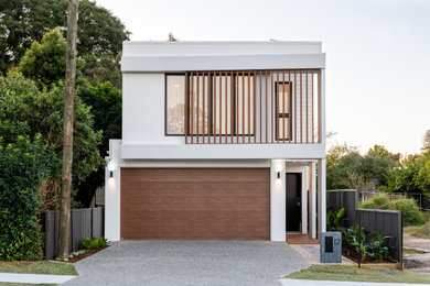 This is an example of a mid-sized contemporary two-storey white house exterior in Brisbane with metal siding, a flat roof, a metal roof and a white roof.