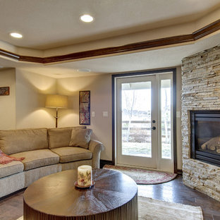 デンバーの大きいトラディショナルスタイルのおしゃれな地下室 (半地下 (窓あり) 、ベージュの壁、無垢フローリング、コーナー設置型暖炉、石材の暖炉まわり、茶色い床) の写真