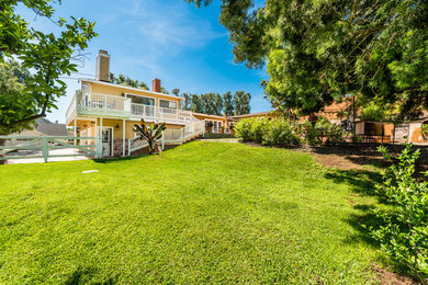 Inspiration for a huge country yellow split-level house exterior remodel in Orange County