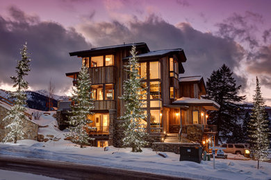 Example of a large mountain style brown three-story wood exterior home design in Salt Lake City with a metal roof
