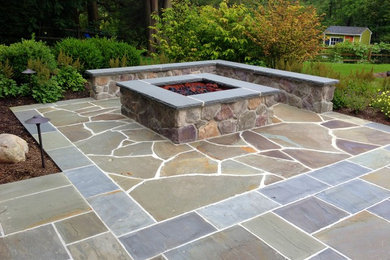 Mid-sized contemporary backyard patio in New York with a fire feature, natural stone pavers and no cover.