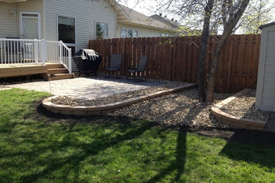 This is an example of a small traditional partial sun backyard retaining wall landscape in Other for summer.