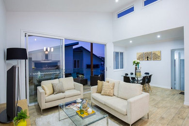 Photo of a small contemporary open concept living room in Brisbane with white walls, light hardwood floors, no fireplace and a freestanding tv.