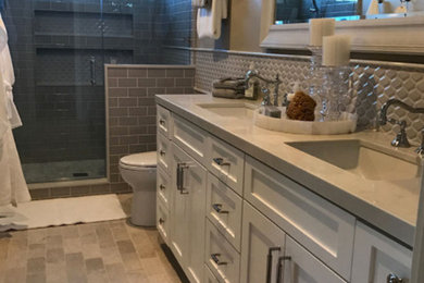 Inspiration for a mid-sized timeless 3/4 beige tile and glass tile brick floor and beige floor bathroom remodel in San Diego with recessed-panel cabinets, white cabinets, beige walls, a drop-in sink and quartz countertops