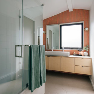 Example of a small coastal master ceramic tile, orange tile and red tile porcelain floor and beige floor bathroom design in Orange County with light wood cabinets, a vessel sink, wood countertops, a hinged shower door, gray countertops, flat-panel cabinets and white walls