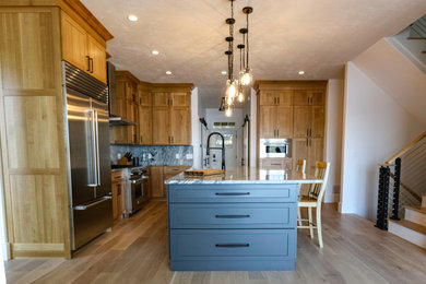 Retro inredning av ett stort flerfärgad flerfärgat kök, med en undermonterad diskho, skåp i shakerstil, granitbänkskiva, flerfärgad stänkskydd, rostfria vitvaror, ljust trägolv, en köksö och gult golv