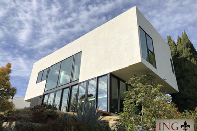 Diseño de fachada de casa beige minimalista de tamaño medio de dos plantas con revestimiento de estuco y tablilla