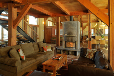 Example of a large arts and crafts dark wood floor and brown floor living room design in Other with a two-sided fireplace and a metal fireplace