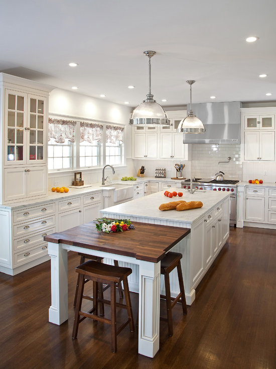 Mid-sized traditional kitchen designs - Kitchen - mid-sized traditional u-shaped dark wood floor kitchen idea in New York with a farmhouse sink, beaded inset cabinets, white cabinets, marble countertops, white backsplash, subway tile backsplash, stainless steel appliances and an island