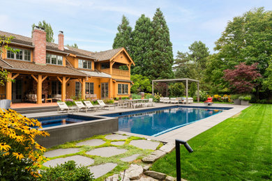 Large trendy backyard concrete paver and rectangular lap hot tub photo in Vancouver