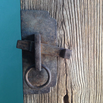 Gorgeous hardware offset by a blue clay wall.