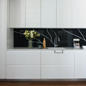 White Kitchen with Light Worktop and Black Veined Splashback