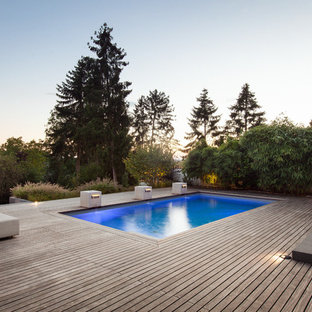 Foto på en funkis pool på baksidan av huset, med trädäck