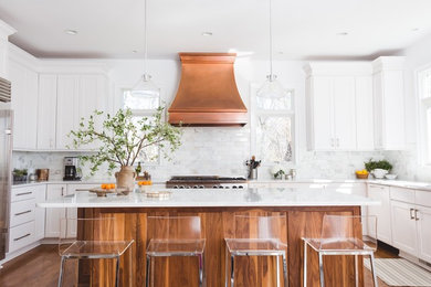 Large transitional u-shaped medium tone wood floor open concept kitchen photo in Los Angeles with shaker cabinets, white cabinets, an island, marble countertops, white backsplash, stone tile backsplash, stainless steel appliances and a single-bowl sink