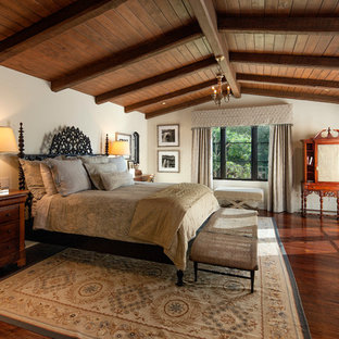Mediterranes Schlafzimmer mit beiger Wandfarbe und dunklem Holzboden in Santa Barbara