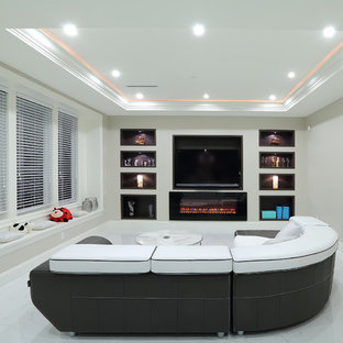 Cette photo montre une salle de cinéma moderne avec un mur gris, un sol en carrelage de céramique et un téléviseur encastré.