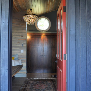 Réalisation d'une porte d'entrée bohème de taille moyenne avec un mur gris, un sol en carrelage de porcelaine, une porte simple, une porte rouge et un sol marron.