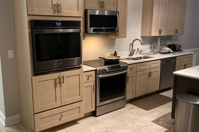 Mid-sized minimalist u-shaped porcelain tile and beige floor eat-in kitchen photo in Atlanta with an undermount sink, shaker cabinets, beige cabinets, quartz countertops, stainless steel appliances, an island and white countertops