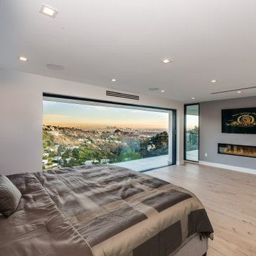 Primary Bedroom with Linear Fireplace and Skyline View