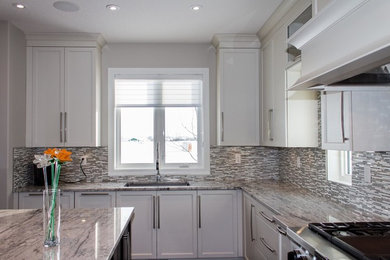 Example of a mid-sized trendy l-shaped eat-in kitchen design in Calgary with a single-bowl sink, shaker cabinets, white cabinets, granite countertops, metallic backsplash, matchstick tile backsplash, stainless steel appliances and an island