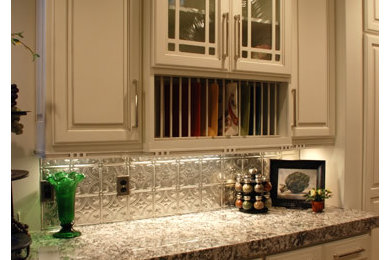 Mid-sized transitional u-shaped light wood floor enclosed kitchen photo in Salt Lake City with raised-panel cabinets, white cabinets, granite countertops, metallic backsplash, ceramic backsplash, stainless steel appliances and no island