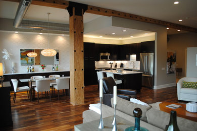 Inspiration for a modern l-shaped medium tone wood floor open concept kitchen remodel in St Louis with an undermount sink, flat-panel cabinets, dark wood cabinets, quartzite countertops, white backsplash, subway tile backsplash, stainless steel appliances and an island