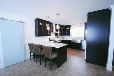 Eat-in kitchen - mid-sized contemporary u-shaped vinyl floor eat-in kitchen idea in Other with a farmhouse sink, flat-panel cabinets, dark wood cabinets, quartz countertops, white backsplash, subway tile backsplash, stainless steel appliances and a peninsula