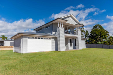 Large two-storey grey house exterior in Brisbane with a gable roof and a metal roof.