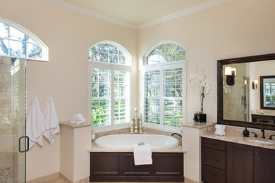 Example of a transitional ceramic tile and beige floor bathroom design in Orlando with recessed-panel cabinets, brown cabinets and granite countertops