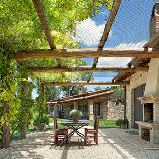 ニューヨークの地中海スタイルのおしゃれなテラス・中庭 (パーゴラ、砂利舗装、屋外暖炉) の写真