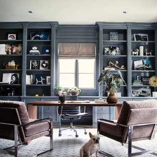 Inredning av ett klassiskt arbetsrum, med grå väggar, mörkt trägolv och ett fristående skrivbord