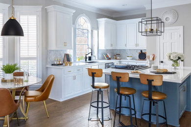 Inspiration for a large 1950s u-shaped medium tone wood floor and brown floor eat-in kitchen remodel in Houston with a drop-in sink, shaker cabinets, white cabinets, quartz countertops, white backsplash, marble backsplash, stainless steel appliances, an island and white countertops