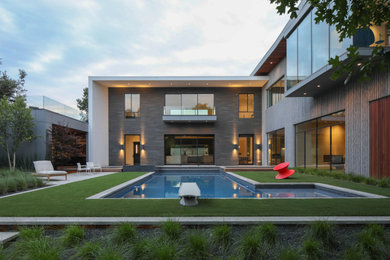 Inspiration for a large contemporary backyard l-shaped pool in Dallas with a hot tub.