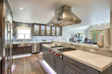 Inspiration for a large modern l-shaped dark wood floor and brown floor open concept kitchen remodel with a farmhouse sink, shaker cabinets, dark wood cabinets, quartz countertops, multicolored backsplash, mosaic tile backsplash, stainless steel appliances, an island and white countertops
