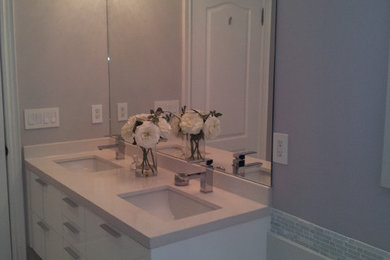 Inspiration for a mid-sized modern 3/4 gray tile, white tile and matchstick tile ceramic tile bathroom remodel in Toronto with flat-panel cabinets, white cabinets, solid surface countertops, purple walls, an undermount sink and a one-piece toilet