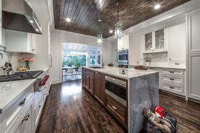 Large transitional enclosed kitchen photo in Boston with an undermount sink, flat-panel cabinets, white cabinets, white backsplash, stainless steel appliances and an island