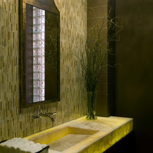 Foto di un piccolo bagno di servizio minimalista con lavabo integrato, top in onice, piastrelle a listelli, pareti gialle, piastrelle beige e top giallo