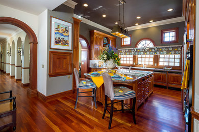 Large elegant u-shaped dark wood floor enclosed kitchen photo in Columbus with an undermount sink, raised-panel cabinets, medium tone wood cabinets, granite countertops, white backsplash, stainless steel appliances and an island