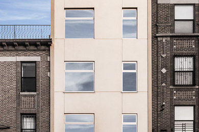Imagen de fachada beige contemporánea pequeña de tres plantas con revestimiento de estuco y tejado plano