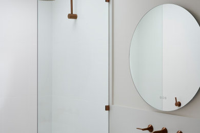 Photo of a mid-sized modern 3/4 bathroom in Adelaide with flat-panel cabinets, medium wood cabinets, an open shower, a one-piece toilet, white tile, porcelain tile, white walls, terrazzo floors, a drop-in sink, engineered quartz benchtops, white floor, an open shower, white benchtops, a single vanity and a floating vanity.