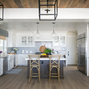 Idéer för mellanstora maritima kök, med en rustik diskho, skåp i shakerstil, vita skåp, bänkskiva i kvarts, blått stänkskydd, stänkskydd i keramik, rostfria vitvaror, en köksö och mörkt trägolv