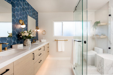 Example of a mid-sized trendy master blue tile and ceramic tile porcelain tile, beige floor and double-sink bathroom design in San Diego with flat-panel cabinets, light wood cabinets, a one-piece toilet, beige walls, an undermount sink, quartz countertops, white countertops and a floating vanity