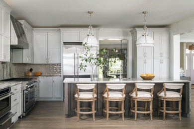 Kitchen - l-shaped medium tone wood floor and brown floor kitchen idea in Baltimore with an undermount sink, shaker cabinets, white cabinets, gray backsplash, stone slab backsplash, stainless steel appliances, an island and gray countertops