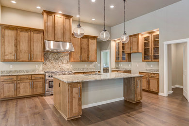 Eat-in kitchen - mid-sized contemporary medium tone wood floor and brown floor eat-in kitchen idea in Seattle with an undermount sink, recessed-panel cabinets, medium tone wood cabinets, granite countertops, multicolored backsplash, stainless steel appliances, an island and stone slab backsplash