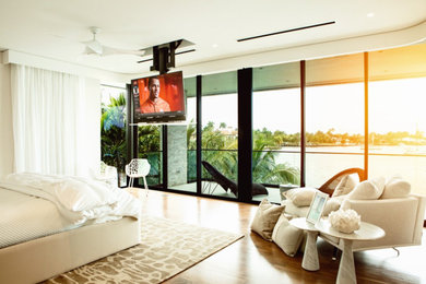 Large contemporary master bedroom in Miami with white walls.