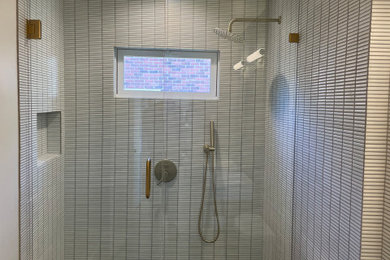 Inspiration for a medium sized modern shower room bathroom in Austin with flat-panel cabinets, light wood cabinets, an alcove shower, a two-piece toilet, white tiles, porcelain tiles, white walls, porcelain flooring, a vessel sink, engineered stone worktops, black floors, a hinged door, grey worktops, a wall niche, double sinks and a floating vanity unit.