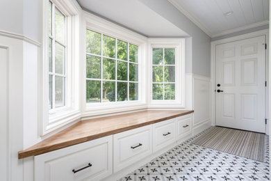 Inspiration for a small transitional ceramic tile, white floor, shiplap ceiling and wainscoting entryway remodel in Grand Rapids with gray walls and a white front door