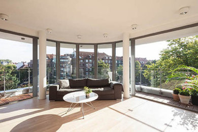 Großes, Repräsentatives, Offenes Modernes Wohnzimmer mit weißer Wandfarbe, hellem Holzboden und TV-Wand in Hamburg