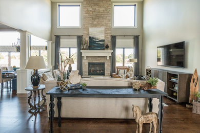 Inspiration for a large arts and crafts family room in Chicago with grey walls, medium hardwood floors, a stone fireplace surround and a wall-mounted tv.