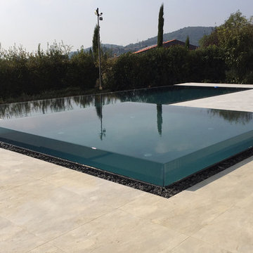 Piscina residenziale esterna con parete in vetro